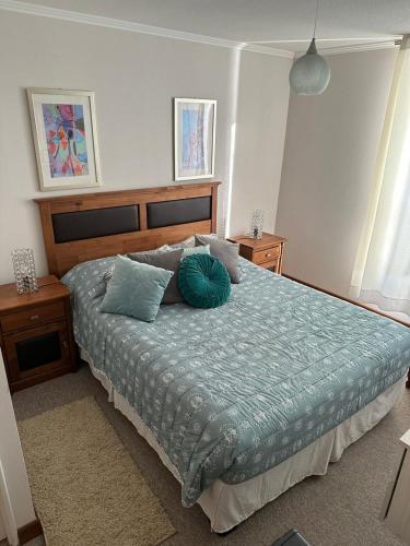 a bedroom with a bed with blue sheets and pillows at Departamento Papudo Laguna in Papudo