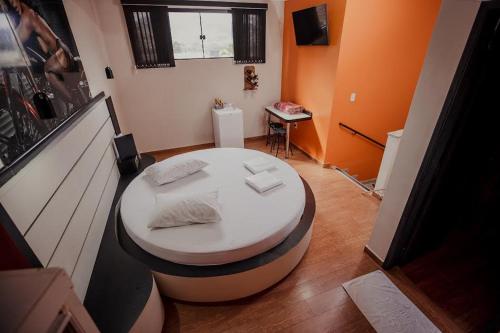 ein Wohnzimmer mit einem weißen Tisch und einem Zimmer in der Unterkunft MOTEL MK 66 in Mairinque