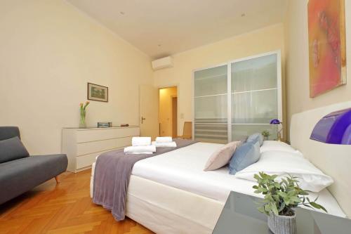 1 dormitorio con 1 cama blanca grande y 1 sofá en Spacious Parioli Apartment en Roma