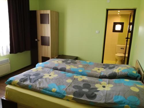 ヒサリャにあるКъща за гости Вила Смокиня град Хисаряのベッドルーム1室(花の咲く青い掛け布団付きのベッド1台付)