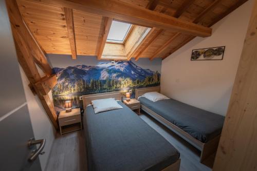 吉列斯特的住宿－le pragmatique，墙上画画的房间里设有两张床