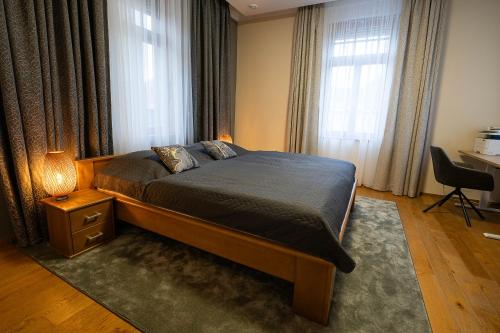 a bedroom with a bed and a desk and windows at Executive 2-Bdrm central suite in Ústí nad Labem
