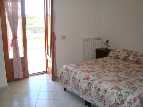 Schlafzimmer mit einem Bett und einer Glasschiebetür in der Unterkunft Villa Leonardo in Ischia