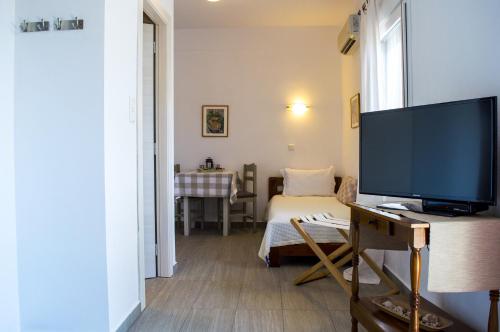 a living room with a television and a bed at Argiro Studios in Skala Rachoniou