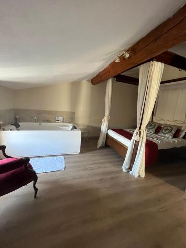 Cette chambre dispose d'une baignoire, d'un lit et d'une baignoire. dans l'établissement La Halte Louis XIII, à Bram