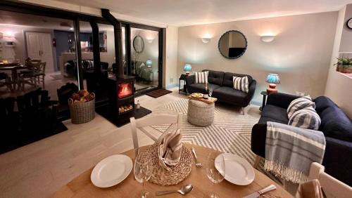 a living room with a couch and a table and a fireplace at Spring Cottage, Little Haven, a minute from beach in Little Haven