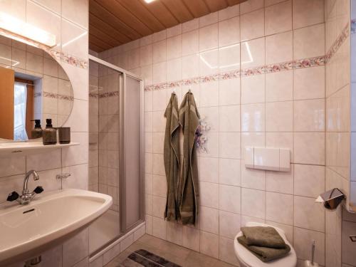 een badkamer met een wastafel, een toilet en een douche bij Appartement Penningdörfl in Hopfgarten im Brixental