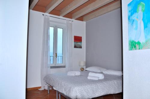 a bedroom with a bed with towels on it at White Garden - Apartment with access to the Lake in Lierna