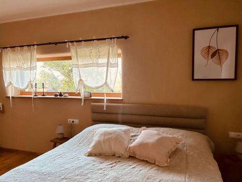a bedroom with a bed with white sheets and a window at Der Hof am Wald in Weichselbaum