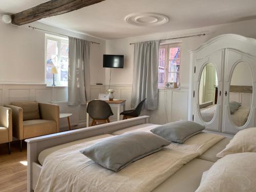 a bedroom with a large bed and a living room at Sonnenhof 1737 - Ferienzimmer & Apartments in Barbelroth