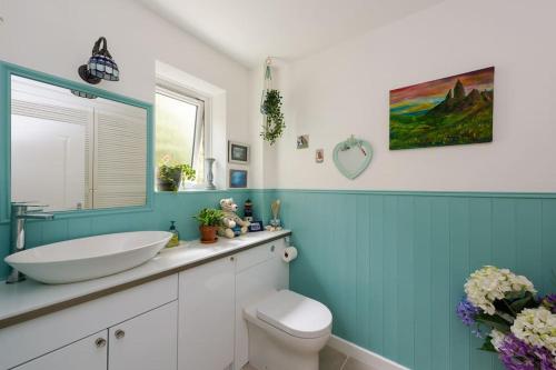 uma casa de banho com um WC branco e um lavatório. em The Chestnuts em Glastonbury