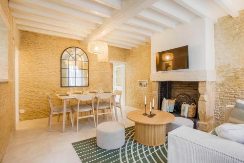 a living room with a table and a fireplace at Single House with Jacuzzi and Sauna in Normandy in Ranville