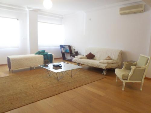 a living room with a couch and a table and chairs at 33 José Farinha in Lisbon