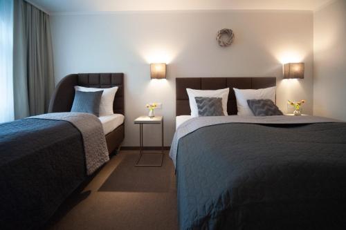 a hotel room with two beds and two lamps at Landhotel Potsdam in Potsdam