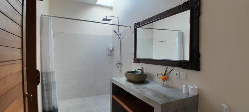 bagno con lavandino e doccia con specchio di Umah Landuh ad Ubud