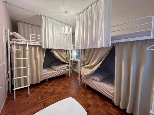 宇和島市にあるDear Uうわじまゲストハウス＆カフェの二段ベッド2台とシャンデリアが備わる客室です。