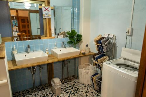 a bathroom with two sinks and a washing machine at Dear Uうわじまゲストハウス＆カフェ in Uwajima