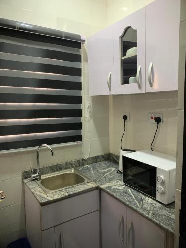 a kitchen with a sink and a microwave at Blueocean.cog in Benin City