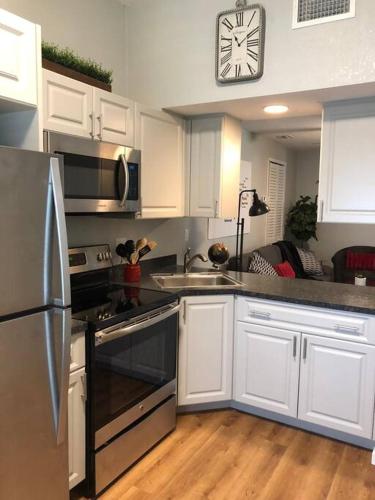 a kitchen with white cabinets and a clock on the wall at Downtown Dunedin! 2 bedroom 2 bath NO KIDS, NO PETS in Dunedin