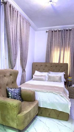 a bedroom with a large bed and a couch at Blueocean.cog in Benin City
