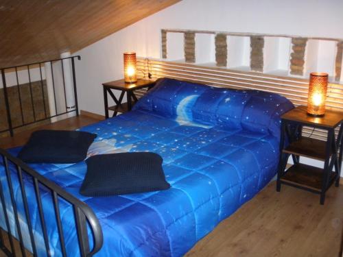 a blue bed in a room with two night stands at Parva Domus in 29 in Morlupo