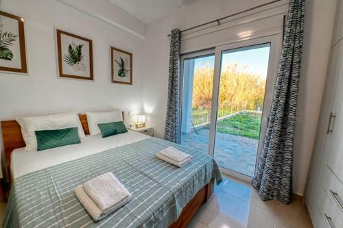 1 dormitorio con cama y ventana grande en Magedico 150m from the beach en Kissamos