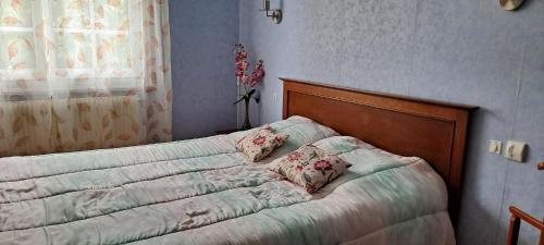 Un dormitorio con una cama con almohadas. en Le Genest St Isles, en Le Genest
