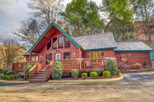 a wooden house with a porch and a fence at Long Overdue in Pigeon Forge