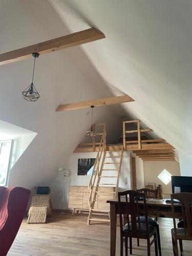 a room with a loft with a ladder and a table at In der Wassermühle in Melle