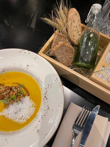 a bowl of soup next to a plate of bread at Złoty Kłos Łapsze Niżne in Łapsze Niżne