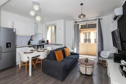 un salon avec un canapé et une table et une cuisine dans l'établissement #Rubis du Sud - Wifi - Clim -Parking - Balcon#, à Toulon