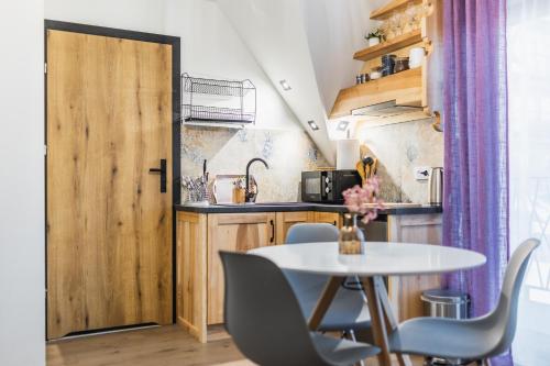 een kleine keuken met een tafel en stoelen en een deur bij Willa na Skarpie in Kościelisko