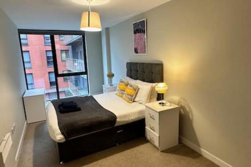 a small bedroom with a bed with a window at Cosy 1 Bed Central Manchester Apartment Sleeps 2 in Manchester