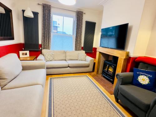 a living room with couches and a tv and a fireplace at Great Town House - Central York in York