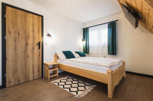 een slaapkamer met een bed en een houten deur bij Willa na Skarpie in Kościelisko