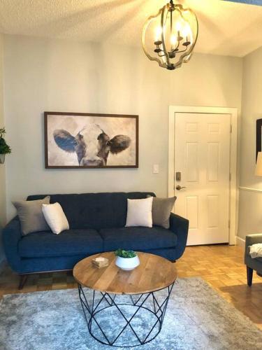 a living room with a blue couch and a table at Overlooking Downtown Dunedin Two Bedroom apartment NO KIDS, NO PETS in Dunedin