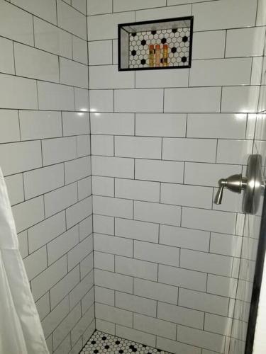 a bathroom with a shower with white tiled walls at Overlooking Downtown Dunedin Two Bedroom apartment NO KIDS, NO PETS in Dunedin