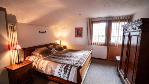 ein Schlafzimmer mit einem großen Bett und einem Fenster in der Unterkunft Singlinaz in Vissoie