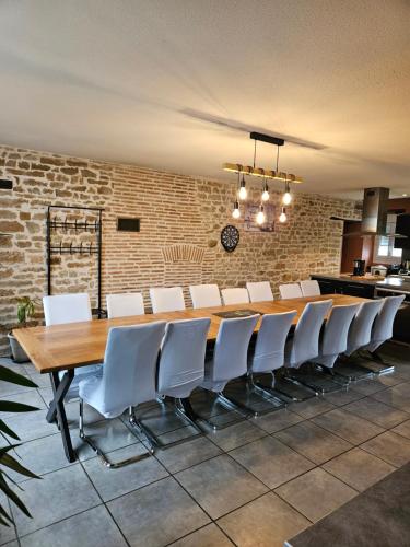 uma sala de conferências com uma mesa de madeira e cadeiras brancas em LA MEUTE em Mars-sur-Allier