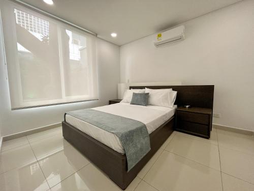ein Schlafzimmer mit einem Bett und einem großen Fenster in der Unterkunft Casa Encanto Del Mar in Cartagena de Indias