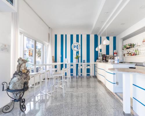 una cocina con paredes a rayas azules y blancas y encimeras blancas en Hotel Majorca, en Gabicce Mare