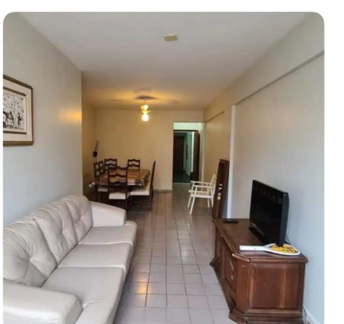 - un salon avec un canapé blanc et une télévision dans l'établissement Condomínio Juacema, à Cabo Frio