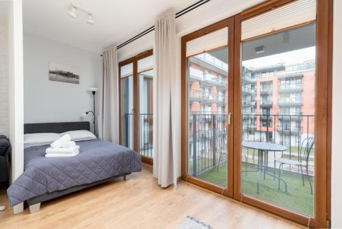 1 dormitorio con 1 cama y balcón en Cracow Novum Apartment #58, en Cracovia