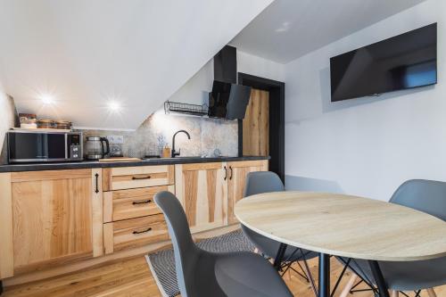a kitchen with a table and some chairs in a room at Willa na Skarpie in Kościelisko