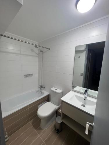 La salle de bains est pourvue de toilettes, d'un lavabo et d'une baignoire. dans l'établissement Depto 2D 2B 6 pax By Terrabahia, à Bahia Inglesa