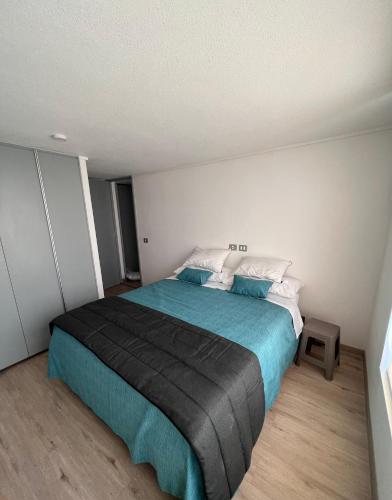 - une chambre dotée d'un grand lit avec des draps bleus dans l'établissement Depto 2D 2B 6 pax By Terrabahia, à Bahia Inglesa