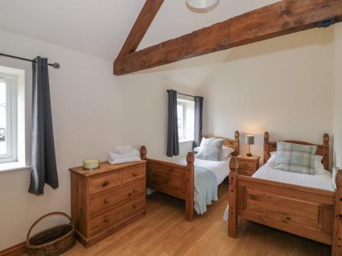 a bedroom with two beds and a mirror at The Hereford Lodge in Stafford