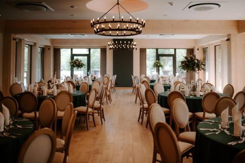 a banquet room with tables and chairs and a chandelier at Złoty Kłos Łapsze Niżne in Łapsze Niżne