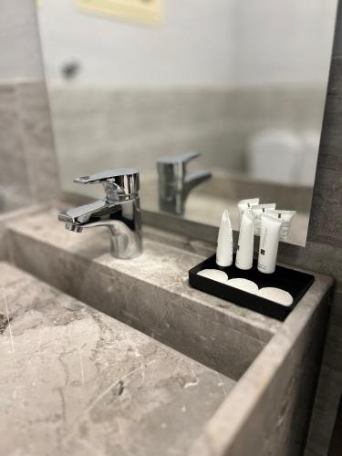 a bathroom sink with two faucets and two rolls of toilet paper at شقق سنتارا الفندقية in Taif