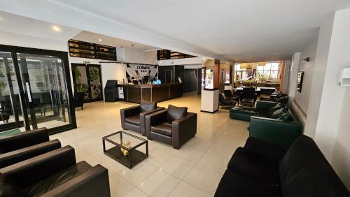 a living room with couches and chairs in a building at Hotel Cosmos in Mar del Plata